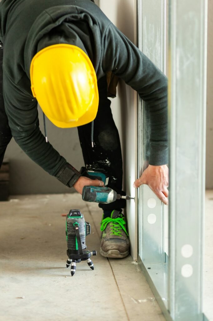 Worker builds a plasterboard wall.